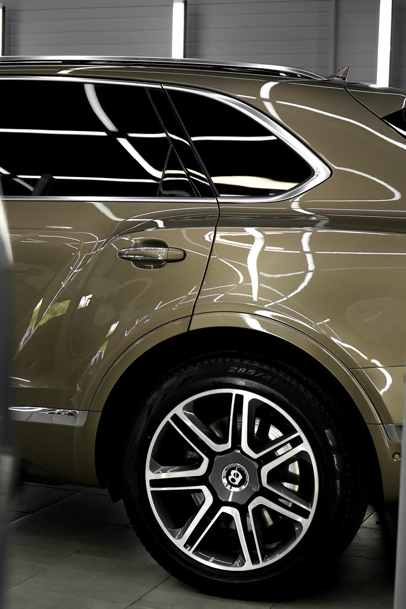 Бок Bentley Bentayga: отражения ламп в лаке