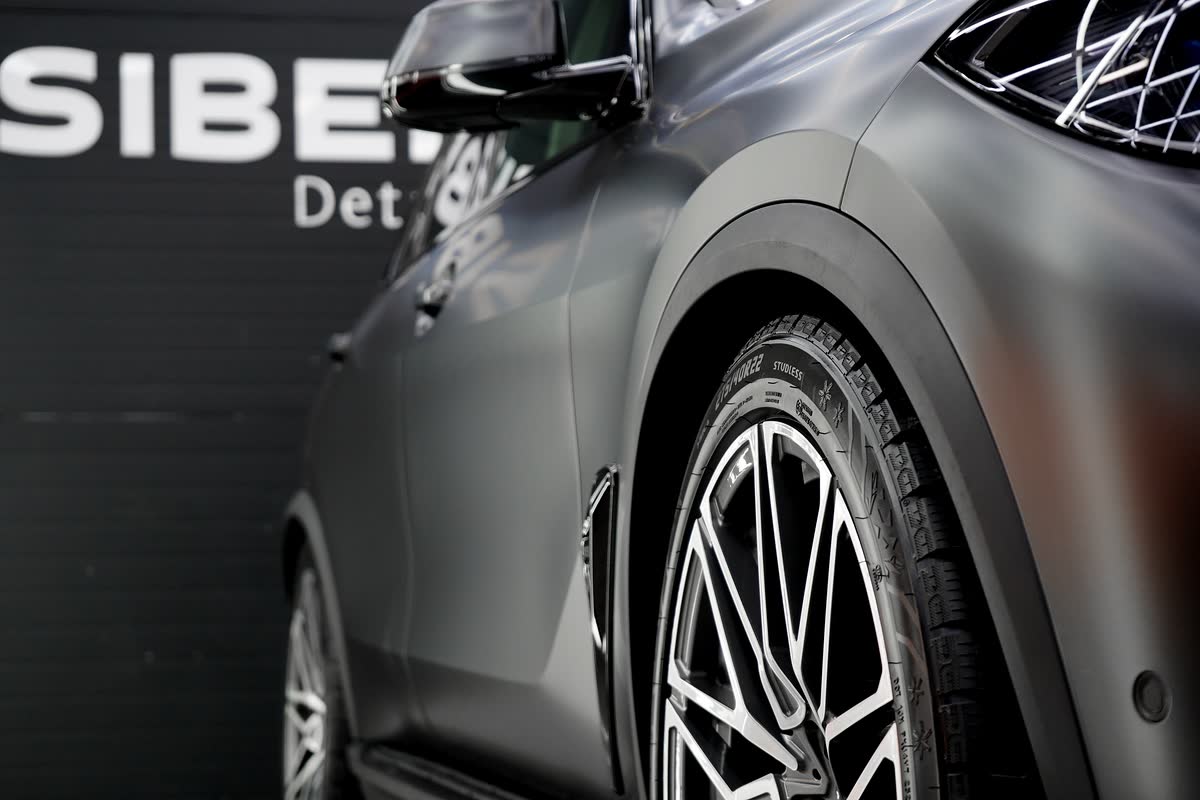 Бок матового BMW X5 у стены студии